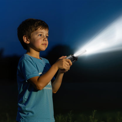 Child holding a flashlight in the dark