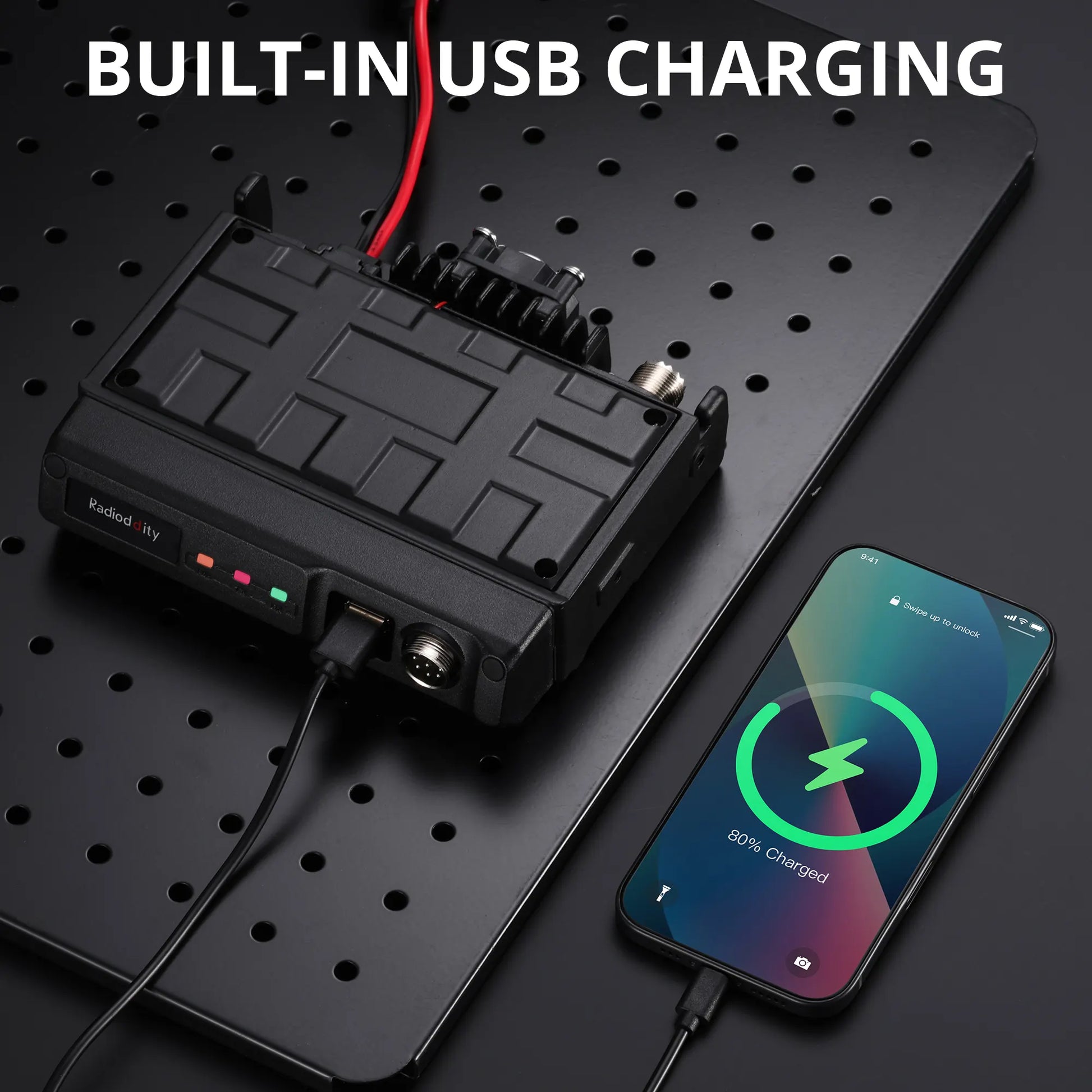 Black battery pack with USB cable connected to a smartphone on a black pegboard background.