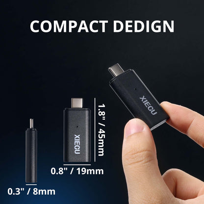 XIEGU device with measurements and a hand holding it against a black background